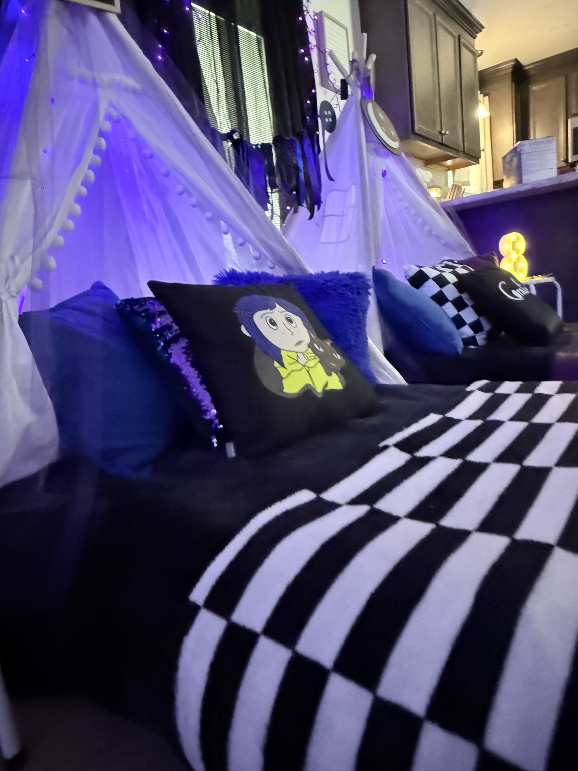 Coraline themed sleepover beds with black, blue, purple, and checkered details